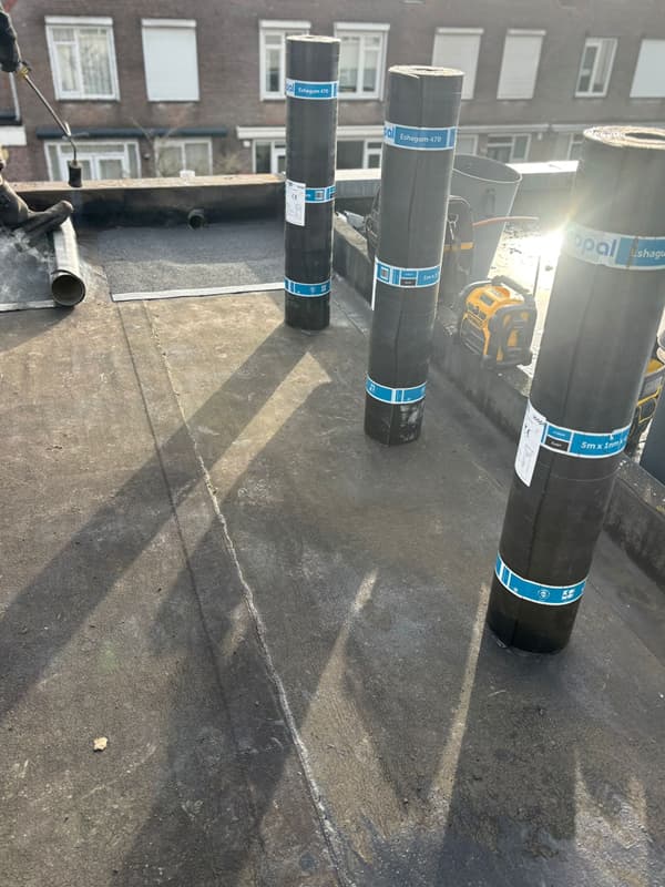 Dakdekkers voeren werkzaamheden uit op een plat dak